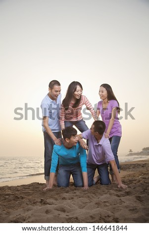 Group of Friends Making Human Pyramid on the Beach