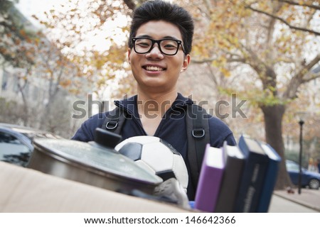 Student in front of dormitory at college