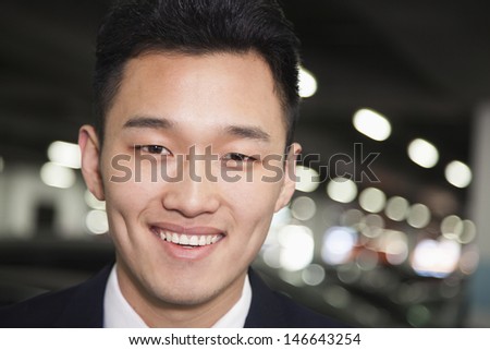 Traveler smiling in airport parking lot