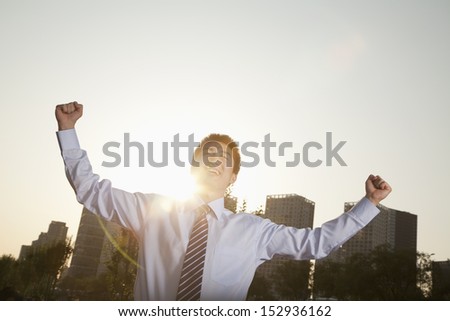 Young businessman with fists in the air celebrating