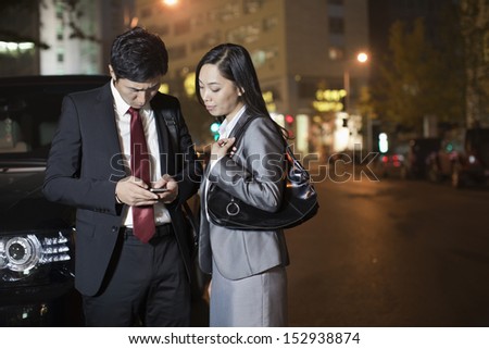 Two Business People Looking At Cell Phone