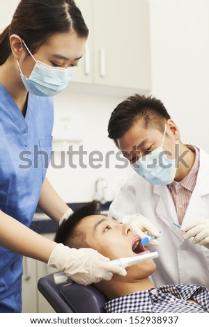 Male Dentist Examining Male Patient