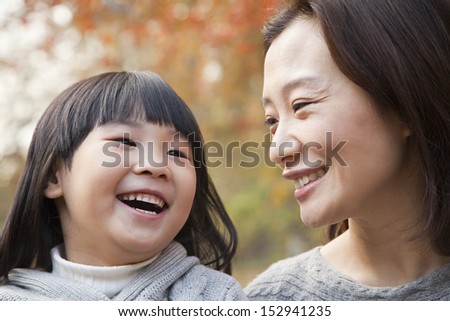 Close-up of Mother and Daughter laughing in the park, autumn, China