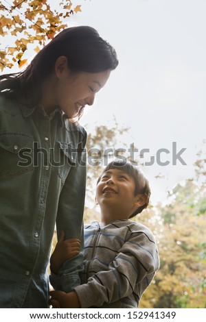 Mother and son walking in the park, holding hands