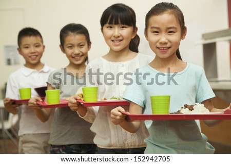 Row of students standing in line in school cafeteria