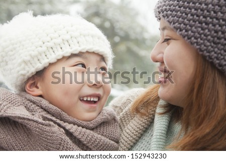 Mother and daughter looking at each other in winter