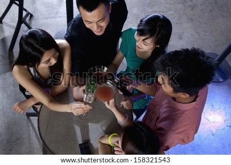Group of friends having drinks in nightclub