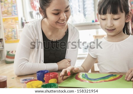 Teacher and student painting in art class