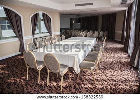 Empty conference room with presentation screen and long table.