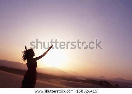 Serene Young Woman With Arms Outstretched Doing Yoga In The Desert