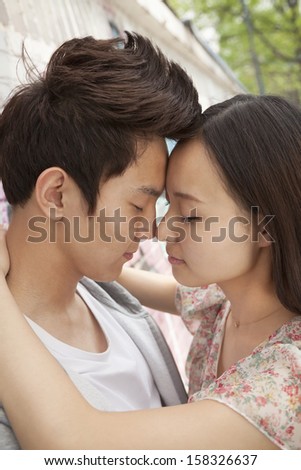 Happy young couple with arms around each other