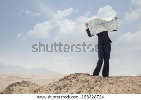 Young Businesswoman looking at map in the middle of the desert