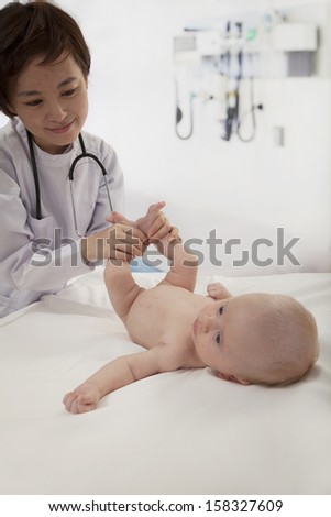 Smiling doctor examining a baby in the doctors office