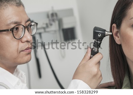 Close-Up of doctor checking the ears of patient