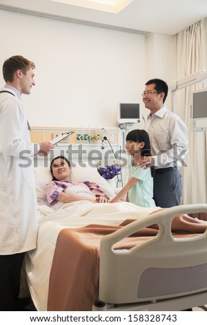 Family visiting the mother in the hospital and discussing with the doctor