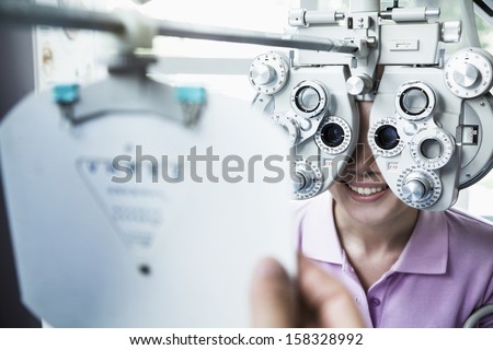 Close-up of optometrist doing eye exam on young woman