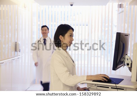 Young female doctor using computer in hospital