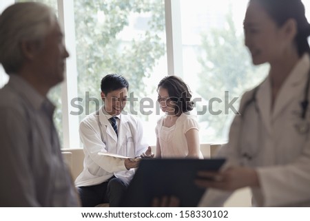 Doctor and patient sitting down and discussing medical record in hospital