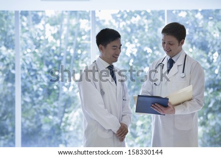 Two doctors consulting about medical record in hospital