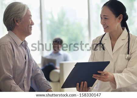 Female Doctor And Patient Discussing Medical Record In The Hospital