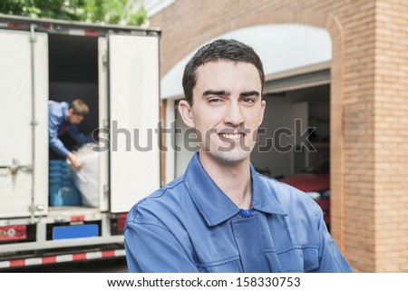 Portrait of smiling mover with moving truck in the background