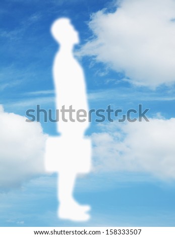 Silhouette of businessman holding a briefcase with a blue sky and clouds behind him