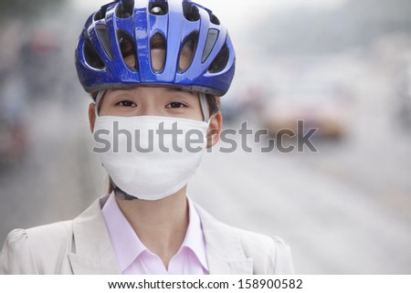 Young business woman wearing bicycle helmet and face mask