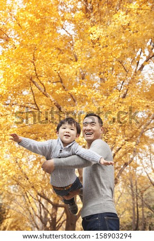 Father and son playing at park in autumn