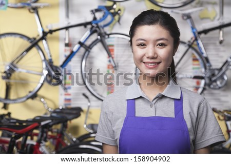 Portrait of young female mechanic in bicycle store
