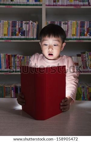 Boy surprised by glowing book