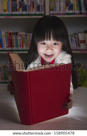 Girl surprised by glowing book