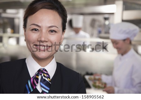 Restaurant hostess in industrial kitchen