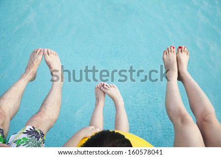 Close-up of feet of family in the pool