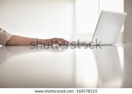 Close up of businesswoman\'s arm using her laptop in office