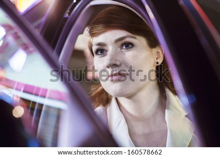 Serene businesswoman opening car door at night