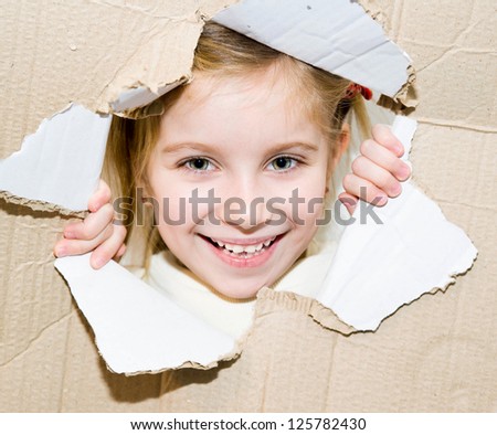 cute funny kid portrait in torn paper hole