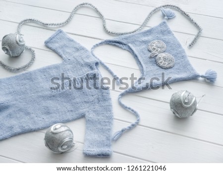 Simple knitted handmade clothes for infant boys, pants and hats, blue and pastel gray, topview