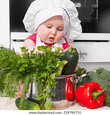 little girl dressed as a chef preparing a meal at home in the kitchen