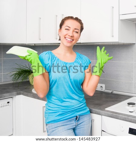 smiling pretty woman cleans the kitchen at home