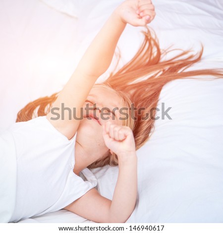 Six Year Old Girl Stretches Himself In White Bed