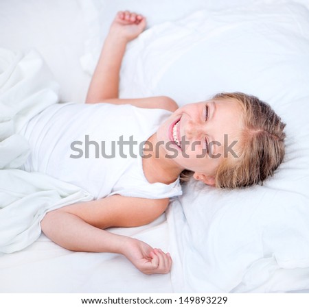 six year old girl lying in white bed