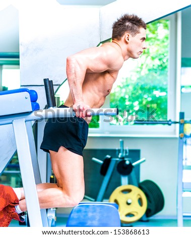 pretty sportsman is engaged in the uneven bars at the gym