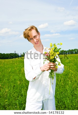 Pretty men with bouquet of flowers on a meadow
