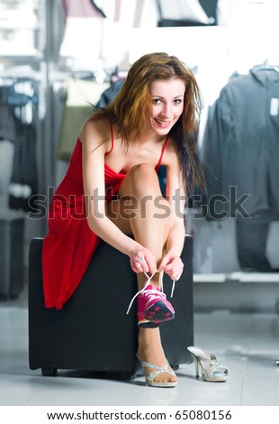 Young women trying on new jogging shoes on the shop