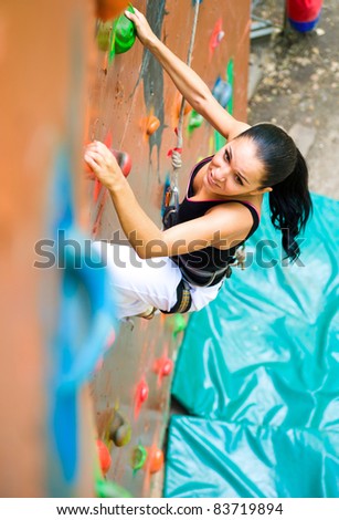 women climbing on a wall in an outdoor climbing center