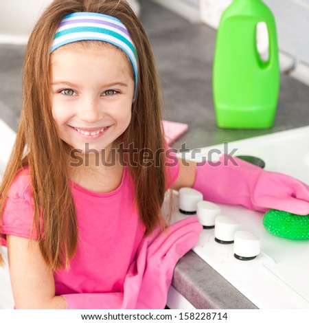 smiling little girl make cleaning in the kitchen