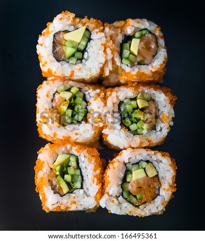 gorgeous sushi  rolls over black background