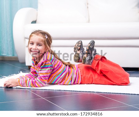 cute little girl playing sports at home in front of a  sofa