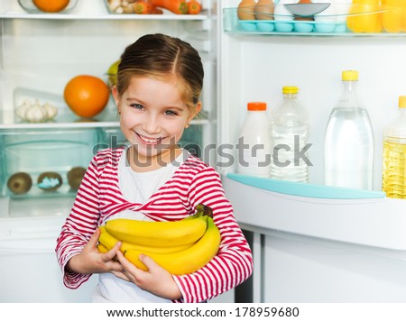 girl with bananas on background refrigerator