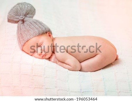 beautiful newborn baby sleeping in knitted cap